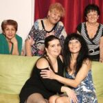 Old and young lesbians perform in a room full of mature ladies