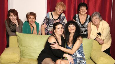 Old and young lesbians perform in a room full of mature ladies